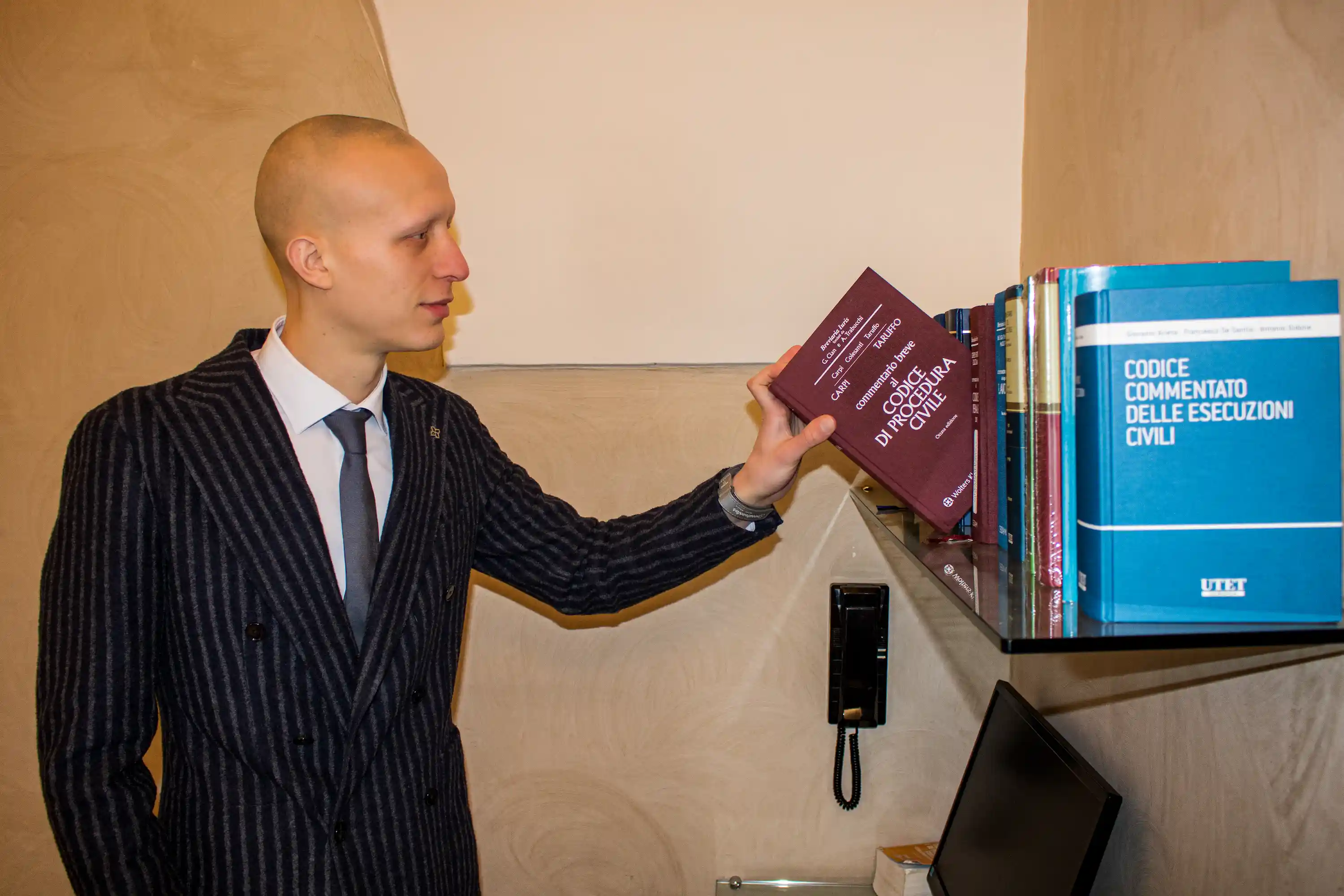 Avv. Matteo Merlicco consulta testi di diritto civile nello studio di Cerignola